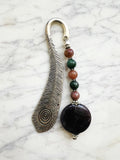 Silver feather bookmark with Amethyst and Indian Agate beads on a marble background