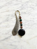 Silver feather bookmark with Amethyst and Indian Agate beads on a marble background