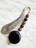 Silver feather bookmark with Amethyst and Indian Agate beads on a marble background