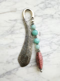 Silver feather bookmark with Amazonite and Rhodochrosite beads on a marble background