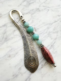 Silver feather bookmark with Amazonite and Rhodochrosite beads on a marble background
