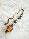 Decorative bookmark with glass beads on a marble surface