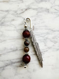 Silver feather bookmark with Carnelian and Indian Agate beads on a marble background