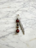 Silver feather bookmark with Carnelian and Indian Agate beads on a marble background
