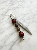Silver feather bookmark with Carnelian and Indian Agate beads on a marble background