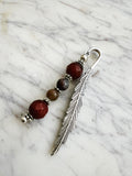 Silver feather bookmark with Carnelian and Indian Agate beads on a marble background