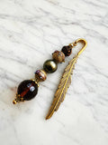 Feather bookmark with beads on a marble surface