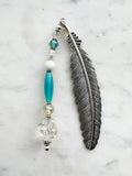 Vintage silver feather bookmark with aqua, pearl, and clear glass beads handcrafted from repurposed vintage jewellery, displayed on a marble background.