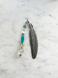 Vintage silver feather bookmark with aqua, pearl, and clear glass beads handcrafted from repurposed vintage jewellery, displayed on a marble background.