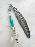 Vintage silver feather bookmark with aqua, pearl, and clear glass beads handcrafted from repurposed vintage jewellery, displayed on a marble background.