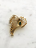 Vintage Gold-Plated Crystal Spray Brooch with Emerald Marquis Center on a marble background