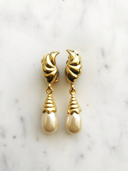 These vintage pearl drop clip on earrings add a little bit of nostalgia to your look! With a timeless design reminiscent of a classic style, these earrings are sure to be a hit with anyone who appreciates a bit of vintage glamour. Dazzle your friends and transport yourself back to a time of art deco elegance!  Gold Plated  Clip On   55mm x 11mm
