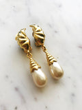 These vintage pearl drop clip on earrings add a little bit of nostalgia to your look! With a timeless design reminiscent of a classic style, these earrings are sure to be a hit with anyone who appreciates a bit of vintage glamour. Dazzle your friends and transport yourself back to a time of art deco elegance!  Gold Plated  Clip On   55mm x 11mm