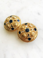 Style up your look with these Vintage Retro Navy Enamel Clip On Earrings. Adorned with a golden finish and intricate patterns, these stunners will add a touch of glam to any look. These earrings are sure to turn heads and inspire compliments, so put ‘em on, show ‘em off, and strut your stuff!  Clip On    Gold Plated  35mm x 35mm