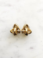 Indulge in the timeless elegance of our Vintage Ribbon Clip On Earrings. Featuring a delicate ribbon design, these earrings add a touch of sophistication to any outfit. With their convenient clip-on style, you can effortlessly add a touch of vintage glamour without the need for pierced ears. Perfect for the modern woman with a love for classic beauty.  Clip On Earrings. Gold Plated  20mm x 25mm