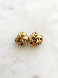 Indulge in the timeless elegance of our Vintage Ribbon Clip On Earrings. Featuring a delicate ribbon design, these earrings add a touch of sophistication to any outfit. With their convenient clip-on style, you can effortlessly add a touch of vintage glamour without the need for pierced ears. Perfect for the modern woman with a love for classic beauty. Clip On Earrings. Gold Plated. 20mm x 20mm.