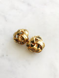 Indulge in the timeless elegance of our Vintage Ribbon Clip On Earrings. Featuring a delicate ribbon design, these earrings add a touch of sophistication to any outfit. With their convenient clip-on style, you can effortlessly add a touch of vintage glamour without the need for pierced ears. Perfect for the modern woman with a love for classic beauty. Clip On Earrings. Gold Plated. 20mm x 20mm.