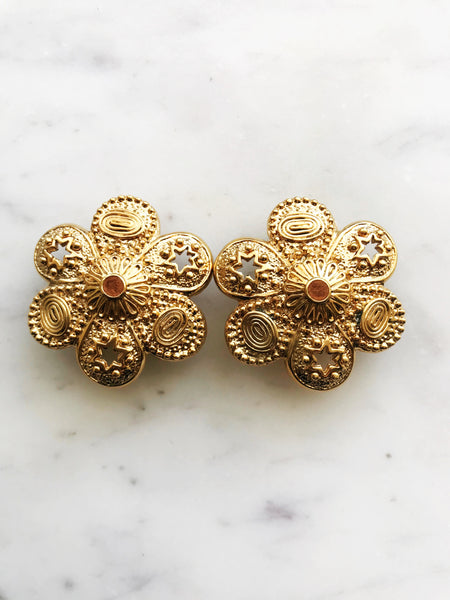 Add a touch of vintage glamour to your look with these playful Golden Stars & Spirals Enamel Clip on Earrings. With their retro design and easy clip-on feature, these earrings will instantly elevate any outfit. Perfect for those who love to make a statement with their style. Clip On Earrings. Gold Plated 40mm x 40mm