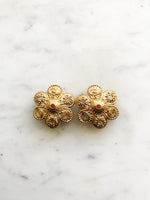 Add a touch of vintage glamour to your look with these playful Golden Stars & Spirals Enamel Clip on Earrings. With their retro design and easy clip-on feature, these earrings will instantly elevate any outfit. Perfect for those who love to make a statement with their style. Clip On Earrings. Gold Plated 40mm x 40mm