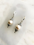 Pair of pearl earrings against a marble background