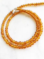 Bohemian Vintage Amber Glass Beaded Necklace Add some vintage charm to your look with this Bohemian Amber Glass Beaded Necklace. Featuring unique amber glass beads, this necklace will add a touch of whimsy to any outfit. Perfect for the free spirit who loves a touch of quirkiness in their fashion. Vintage glass beads 45cm