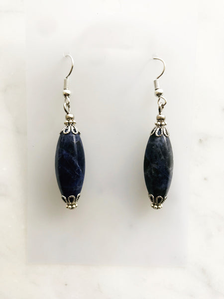 Tibetan Silver Sodalite Crystal Earrings Sodalite is a blue crystal that symbolizes wisdom, clarity, and intuition. It helps to improve one's mental abilities, such as analysis, logic, and problem-solving. It also facilitates spiritual growth and enlightenment, as it connects to the energy of the sky. Sodalite is a stone of insight, awareness, and calmness 30mm x 10mm Sodalite Crystal 55mm drop from the top of the ear hook Nickel free ear hooks for sensitive skin