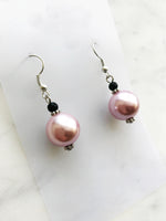 Spice up your earring collection with these quirky handmade Vintage Pink Glass Pearl and black glass bead earrings. Channel retro vibes and unleash your playful side while rocking these unique and stylish accessories. Perfect for adding a touch of fun to any outfit.  Handmade using vintage pink glass pearls and black glass beads.  45mm x 13mm  Nickle free ear hooks for sensitive ears