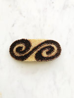 Add some vintage charm to your hair with this hand-crafted seed bead barrette. Made in France, it's a unique and stylish accessory that will elevate any hairstyle. Perfect for adding a touch of playfulness to your look! 107mm x 45mm