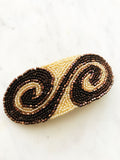 Add some vintage charm to your hair with this hand-crafted seed bead barrette. Made in France, it's a unique and stylish accessory that will elevate any hairstyle. Perfect for adding a touch of playfulness to your look! 107mm x 45mm