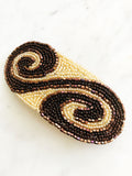 Add some vintage charm to your hair with this hand-crafted seed bead barrette. Made in France, it's a unique and stylish accessory that will elevate any hairstyle. Perfect for adding a touch of playfulness to your look! 107mm x 45mm