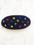 Add a touch of retro beauty to your hair with this Vintage Seed Bead Flower Barrette. The colorful, delicate beads create a charming flower design, making this barrette a unique and playful addition to any hairstyle. So go ahead, channel your inner flower child with this vintage-inspired hair accessory.  Made by hand  97mm x 45mm