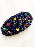 Add a touch of retro beauty to your hair with this Vintage Seed Bead Flower Barrette. The colorful, delicate beads create a charming flower design, making this barrette a unique and playful addition to any hairstyle. So go ahead, channel your inner flower child with this vintage-inspired hair accessory.  Made by hand  97mm x 45mm