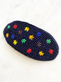 Add a touch of retro beauty to your hair with this Vintage Seed Bead Flower Barrette. The colorful, delicate beads create a charming flower design, making this barrette a unique and playful addition to any hairstyle. So go ahead, channel your inner flower child with this vintage-inspired hair accessory.  Made by hand  97mm x 45mm