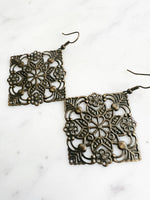 Large Antique Bronze Vintage Filigree Square Earrings
Add a touch of whimsy with these Vintage Filigree Earrings. These lightweight beauties feature intricate filigree designs for a boho vibe. Perfect for a playful and carefree look.
Lightweight brass metal stampings with an antique bronze patina.
65mm from the top of the ear hook x 49mm