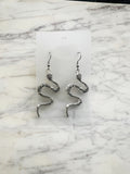 Coiled serpent Tibetan silver dangle earrings on surgical steel hooks, front view