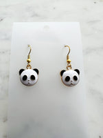 Enamel Panda earrings on a marble background