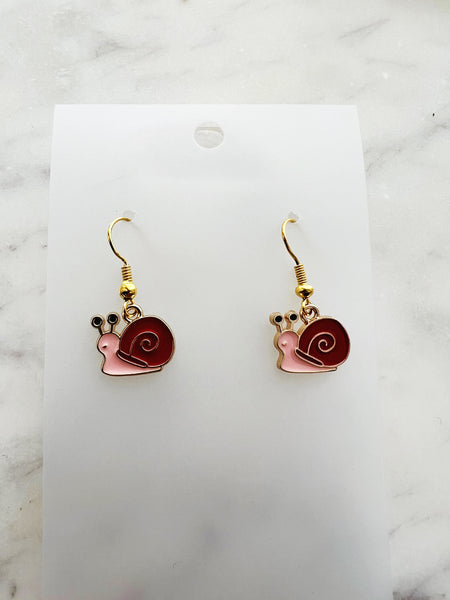 Snail-shaped earrings on a white card with a marble background