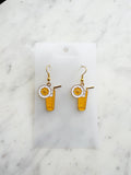Pair of kawaii earrings with a cocktail design on a marble background
