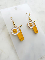 Pair of kawaii earrings with a cocktail design on a marble background