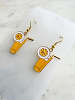 Pair of kawaii earrings with a cocktail design on a marble background