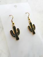 Kawaii Cactus-shaped earrings on a white card with a marble background