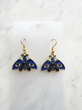 Kawaii Blue moth with evil eye earrings on a white marble background