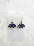 Kawaii Blue moth with evil eye earrings on a white marble background