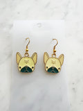 Kawaii Gold French bulldog earrings on a white card with a marble background