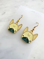 Kawaii Gold French bulldog earrings on a white card with a marble background