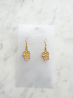 Kawaii Cupcake-shaped earrings on a clear card with a marble background