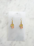 Kawaii Cupcake-shaped earrings on a clear card with a marble background