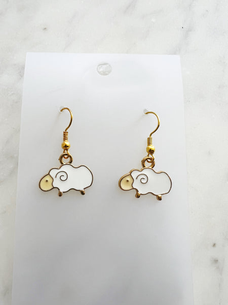 Kawaii Sheep-shaped earrings on a white card with a marble background