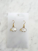 Kawaii Sheep-shaped earrings on a white card with a marble background