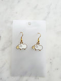 Kawaii Sheep-shaped earrings on a white card with a marble background